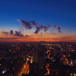 Illuminated cityscape against sky at night