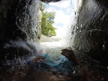 Close-up of water flowing over river against sky