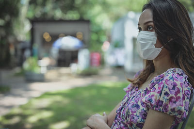 Young woman in daydream emotion , outdoor with surgical protection mask
