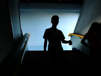 Silhouette man walking down stairs at subway
