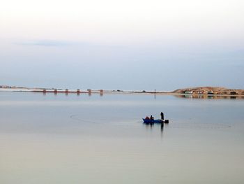 Men in boat on sea against sky