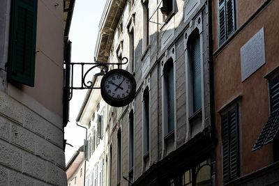 Low angle view of clock on wall by building