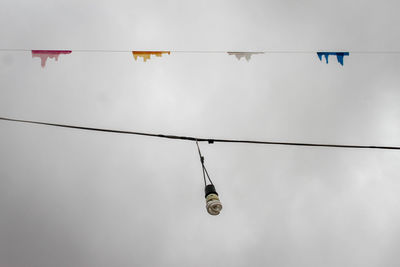 Low angle view of cable hanging against sky