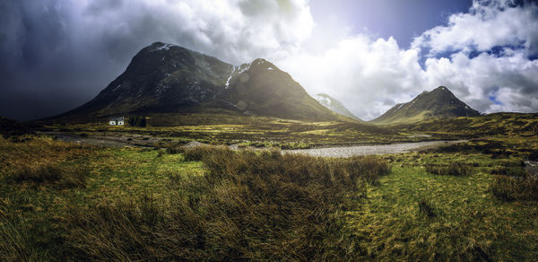 Scenic view of mountains against cloudy sky