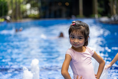 Portrait of cute girl standing in swimming pool