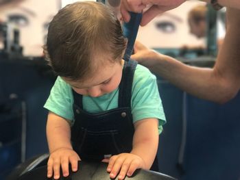 Baby boy having haircut in salon