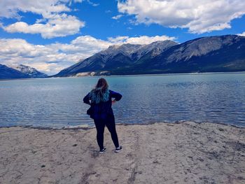 Rear view of woman standing at riverbank