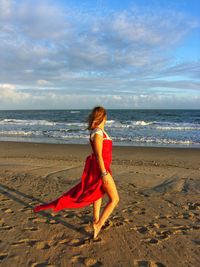 Full length of woman on beach against sky