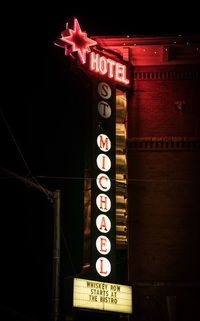 Low angle view of information sign at night