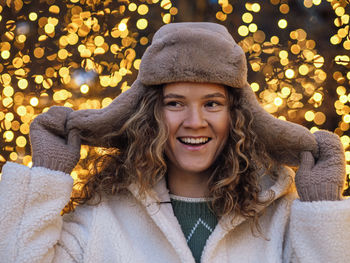 Portrait of young woman wearing hat at night