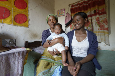 Madagascar, fianarantsoa, baby boy, mother and grandmother sitting in livingroom