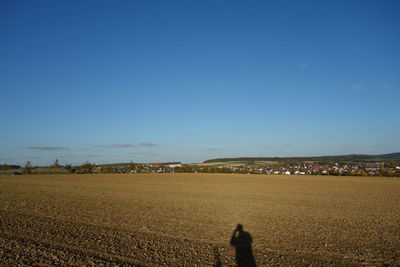 Scenic view of field against clear blue sky