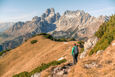 Woman hiking on footpath in alpine landscape in autumn, bischofsmütze, filzmoos, austria