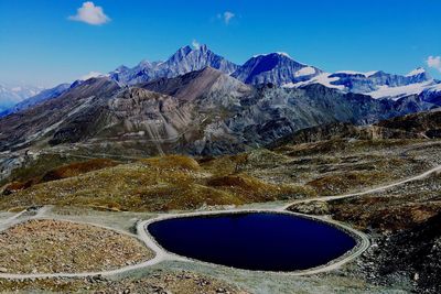 Scenic view of snowcapped mountains against blue sky