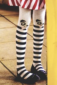Low section of girl wearing striped panda sock