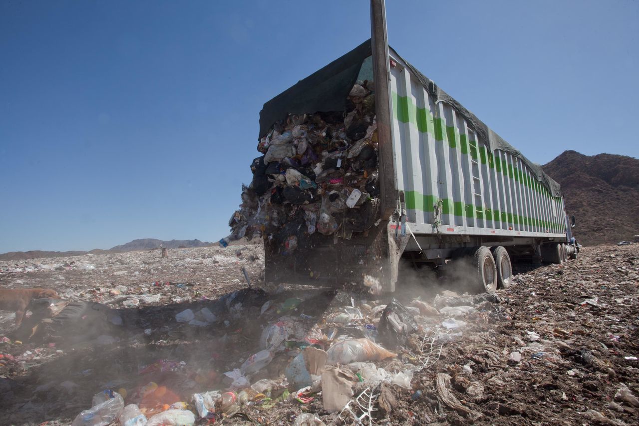 GARBAGE BY BUILDING AGAINST SKY