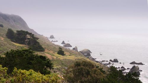 Scenic view of sea and mountains against sky