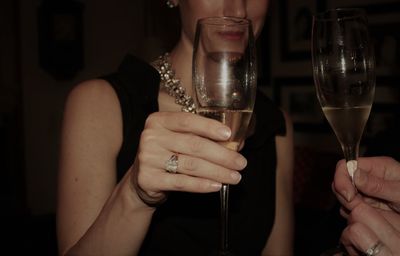 Midsection of woman holding wine glass