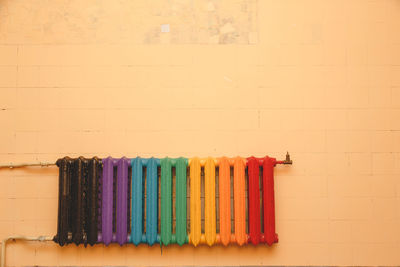 Close-up of multi colored pencils on table against wall