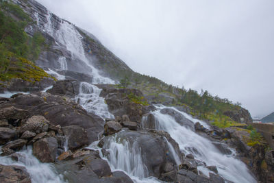 Scenic view of waterfall against sky