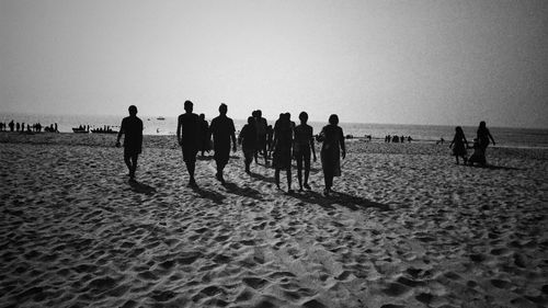 People enjoying at beach against sky