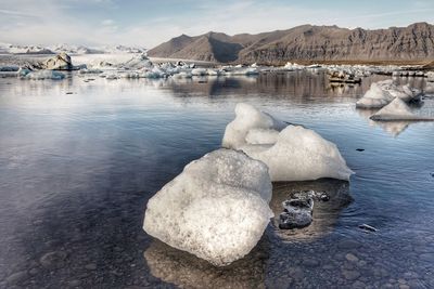 View of frozen lake with mountains in background