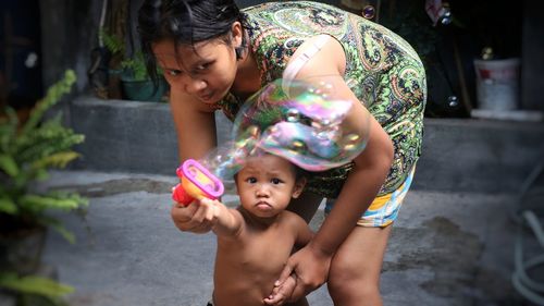 Portrait of happy girl holding mother and daughter