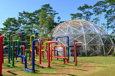 View of playground against blue sky in park