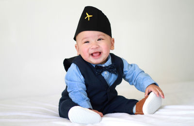 Portrait of cute girl sitting against white background