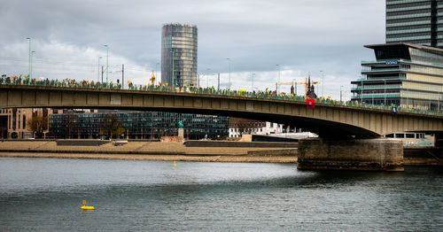 Bridge over river in city against sky