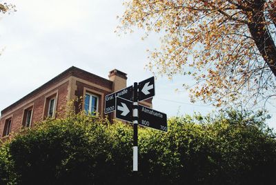 Low angle view of sign by building against sky