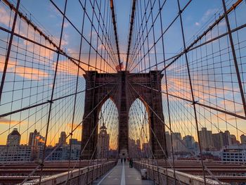 Bridge in city against sky during sunset