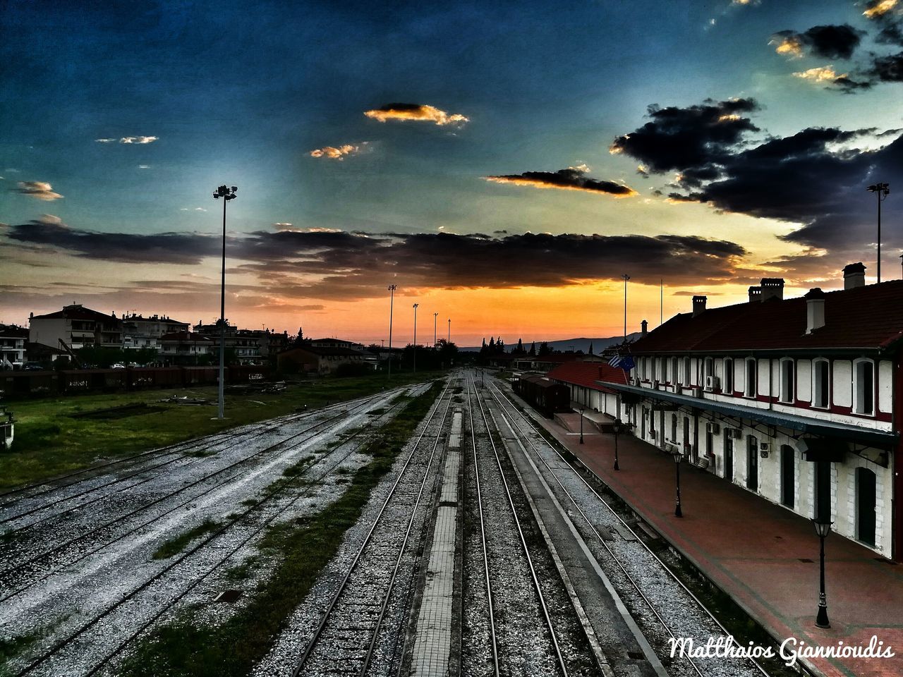 RAILROAD TRACKS AGAINST SKY DURING SUNSET