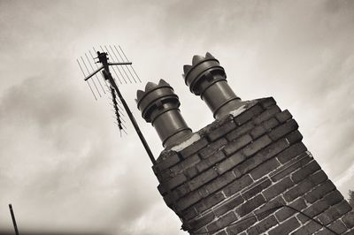 Low angle view of crane against cloudy sky