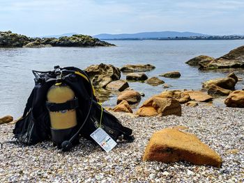 Scenic view of sea shore against sky with scuba diving equipment