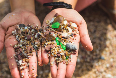 Close-up hand holding the colorful pebbles from the phetra national park in thailand