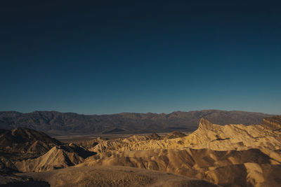 Scenic view of desert against clear blue sky