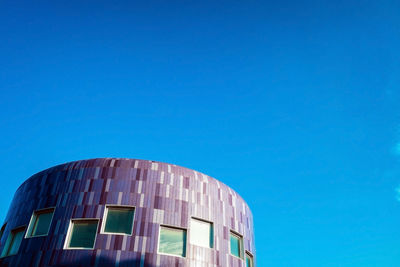 Low angle view of modern building against clear blue sky