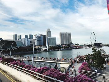 Modern buildings by river against sky in city