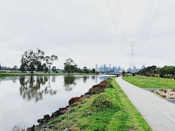 Panoramic view of road by trees against sky