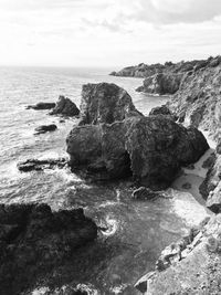 Rocks on beach against sky