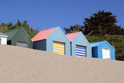 Brightly coloured beach huts positioned in a row at the top of a beautiful abersoch beach