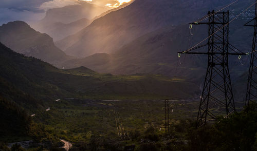 Electricity pylon on land against sky. sunset in the mountains of dagestan