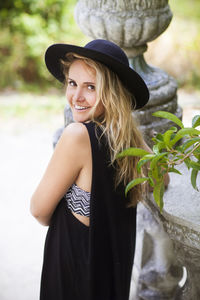 Portrait of young woman wearing hat standing outdoors