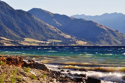 Scenic view of sea and mountains against sky