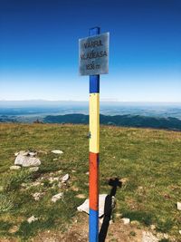 Information sign on wooden post against sky