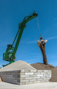 Exterior view of a cement factory with green crane