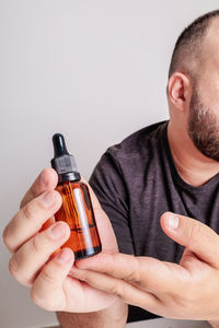 Man holding bottle against white background