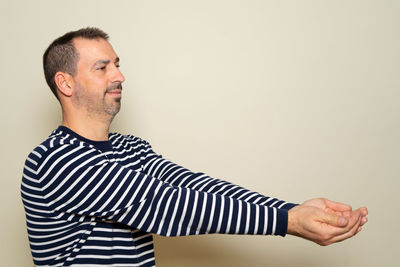 Side view of man standing against white background
