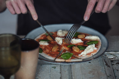 Close-up of human hands cutting food